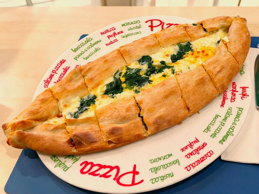 Ofenfrische Pide mit Spinat und Käse serviert auf einem Teller