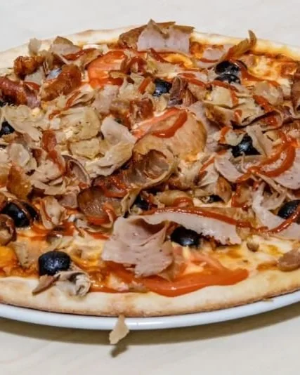 Frisch servierte Pizza mit Kebabfleisch und Oliven
