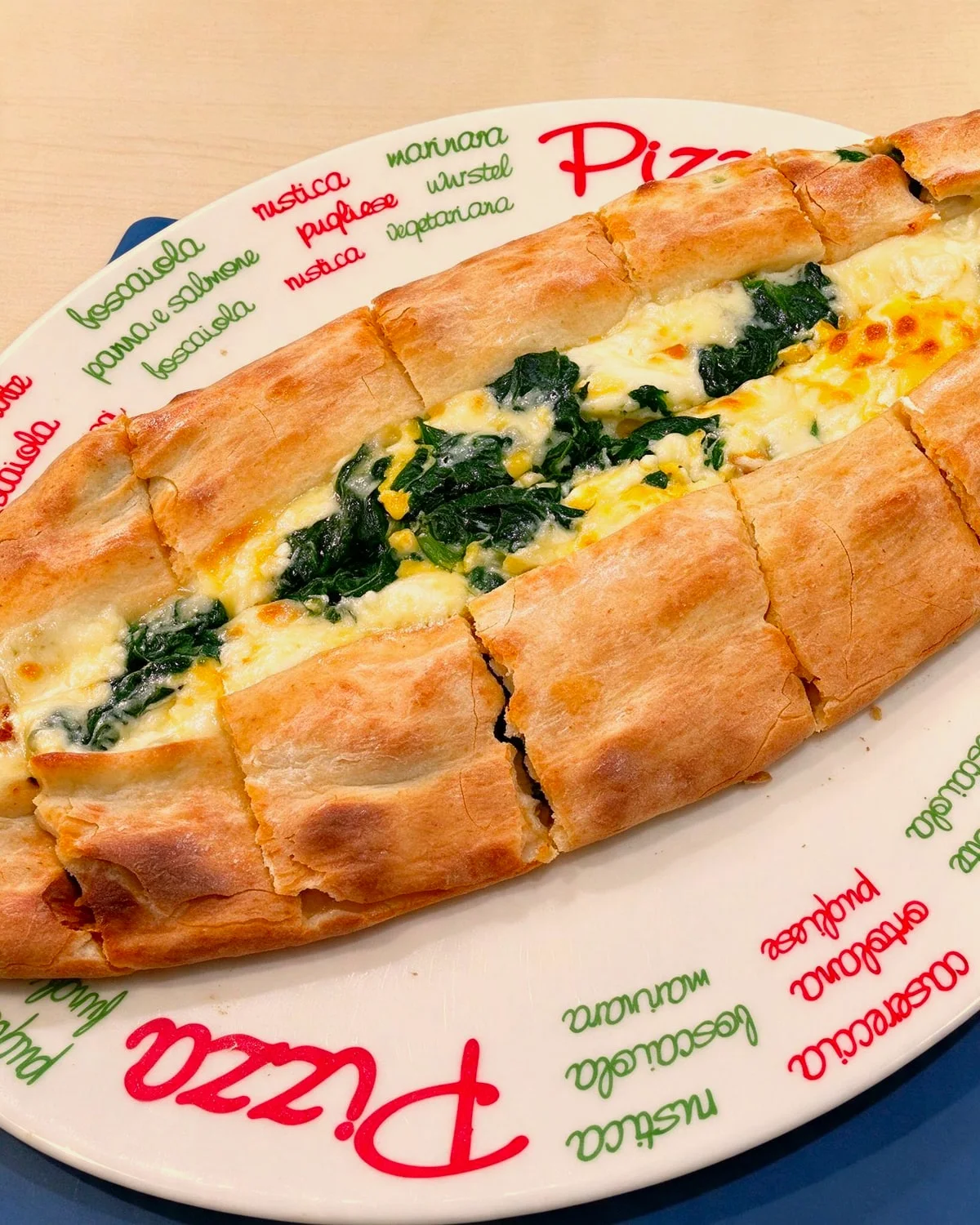 Ofenfrische Pide mit Spinat und Käse auf einem Teller