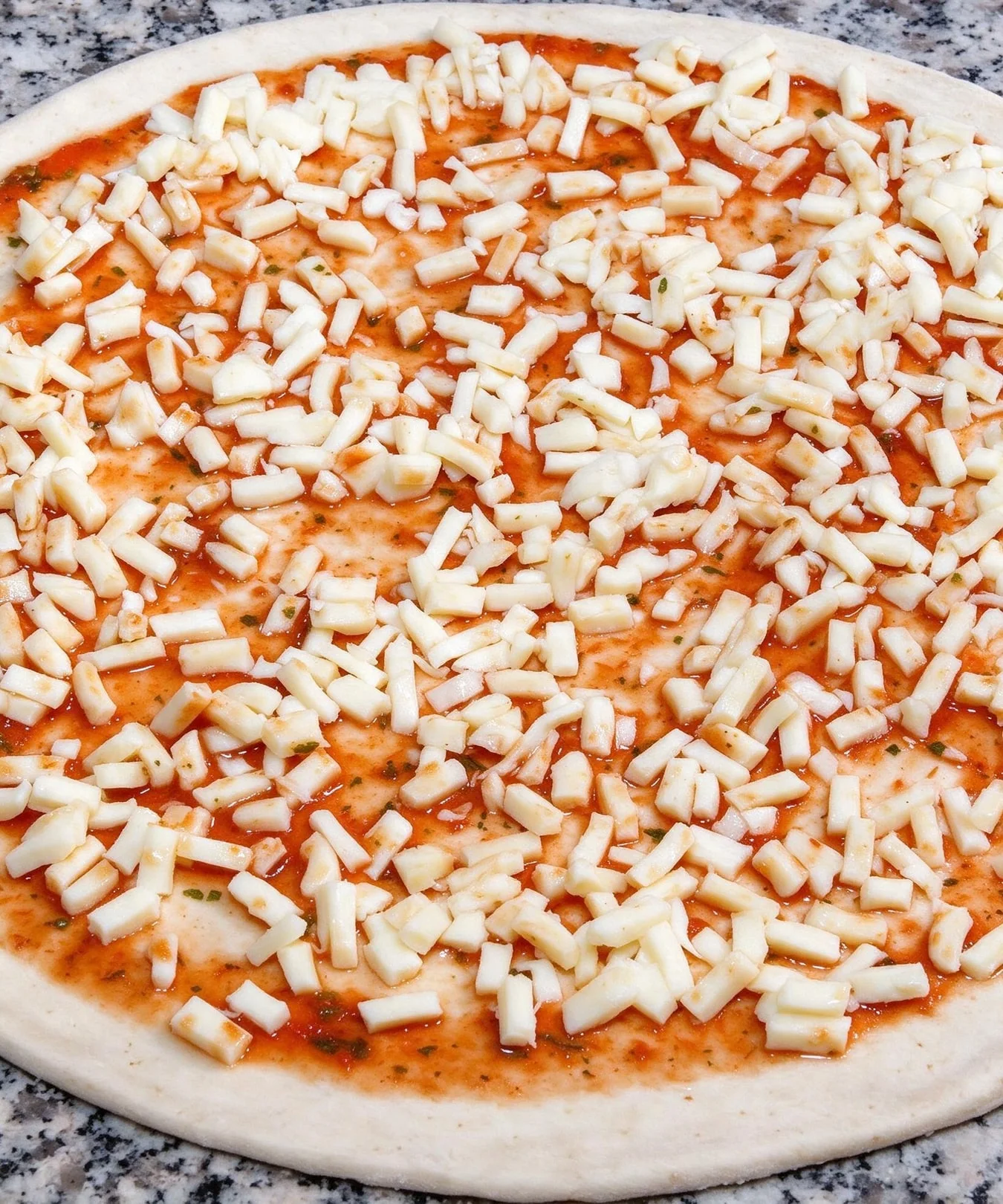 Zubereitung von frischem Pizzateig auf einer Arbeitsfläche